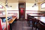 Saloon of the Sybaris with wooden dining tables and benches
