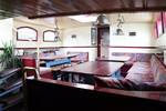 Saloon of the Sybaris with wooden dining tables and benches