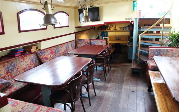 Saloon of the Sybaris with wooden dining tables and benches
