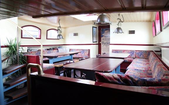 Saloon of the Sybaris with wooden dining tables and benches