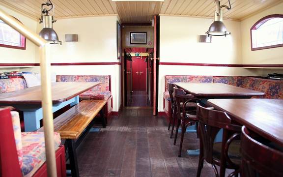 Saloon of the Sybaris with wooden dining tables and benches
