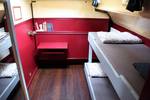 Cabin of the Sybaris with bunk beds and a red bench