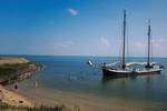 Sybaris at anchor beside a sandy shore