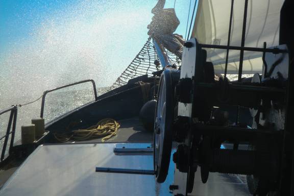 Water splashing over the foredeck of the Sybaris while sailing