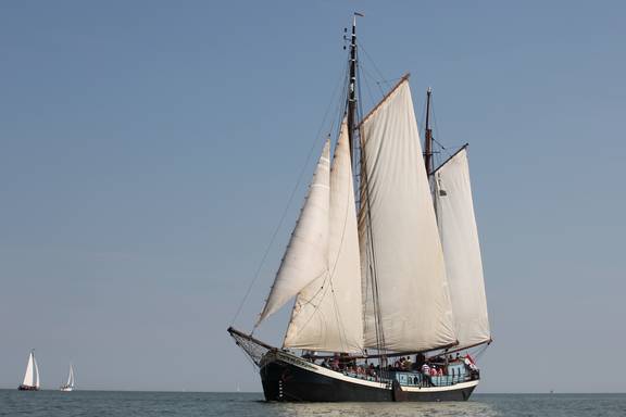 Clipper Sybaris under white sails on the water