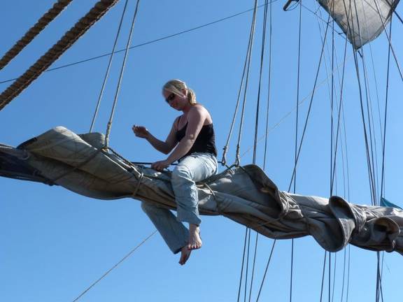 Sailor sitting on the boom of the Thalassa