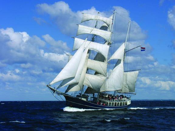 Tall ship Thalassa under full sail at sea
