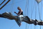 Sailor sitting on the boom of the Thalassa