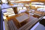 Deck seating area with wooden benches and a table on the Tsjerk Hiddes