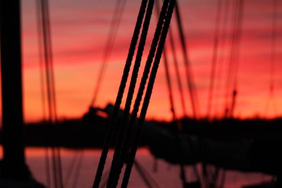 Ropes of the Tsjerk Hiddes against a red evening sky