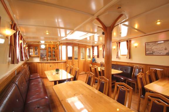 Saloon of the Tsjerk Hiddes with wooden tables and leather benches