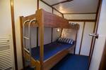 Twin-berth cabin with a wooden bunk bed on the Utopia