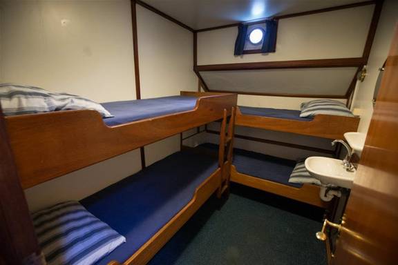 Four-berth cabin with bunk beds and a washbasin on the Utopia