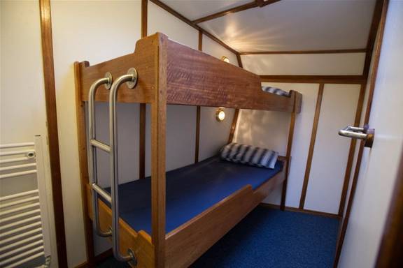 Twin-berth cabin with a wooden bunk bed on the Utopia