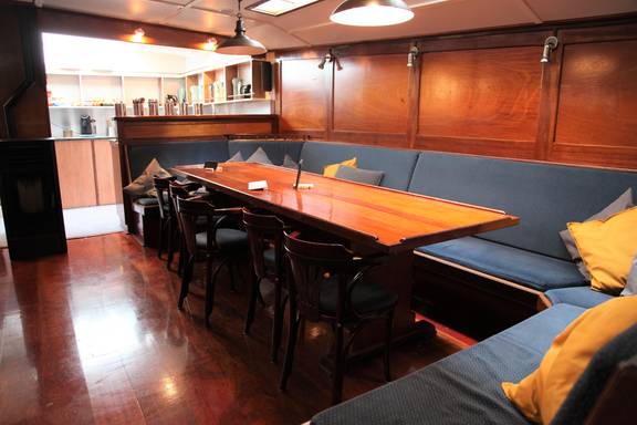 Saloon of the Vrijheid with wooden dining tables and benches
