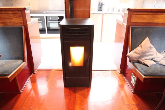 Lit stove between the benches in the saloon of the Vrijheid