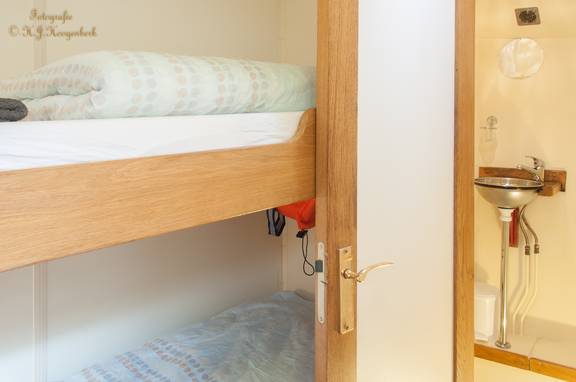 Twin-berth cabin with a bunk bed aboard De Vrouw Dina