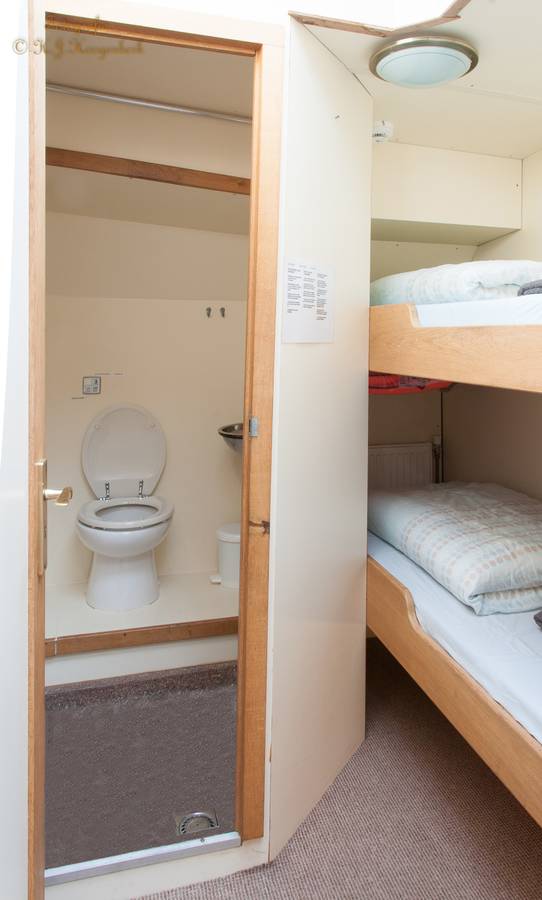 Twin-berth cabin with a bunk bed and private bathroom on De Vrouw Dina