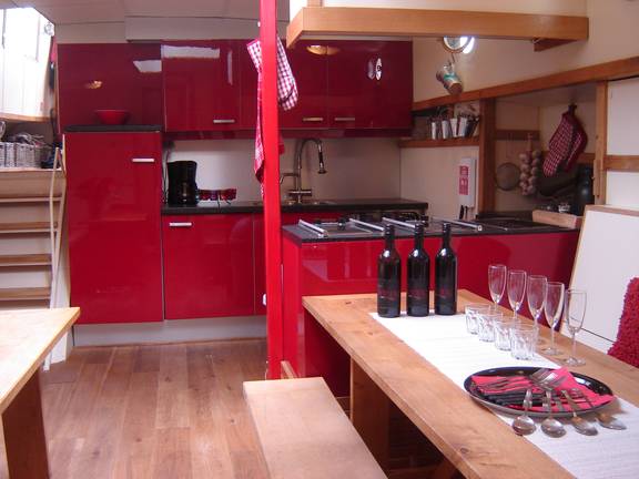 Red galley and wooden dining tables on De Vrouw Dina