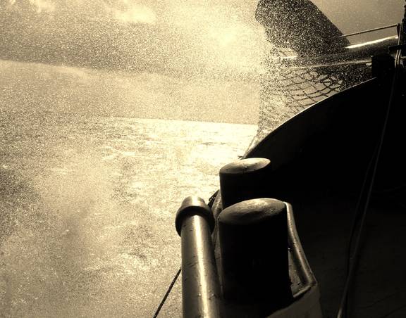 Water spraying beside the hull of De Vrouw Dina while sailing