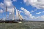Clipper Waterman under white sails beneath a blue sky with clouds