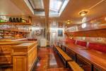 Wood-panelled saloon of the Waterman with dining tables and red benches
