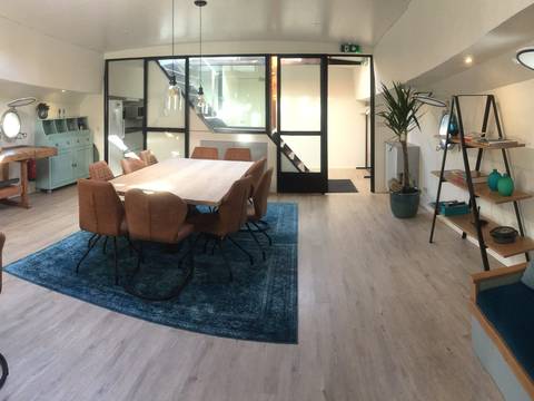 Bright living room with a dining table and glass wall on the Wilhelmina