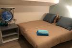 Cabin of the Wilhelmina with a double bed and round portholes