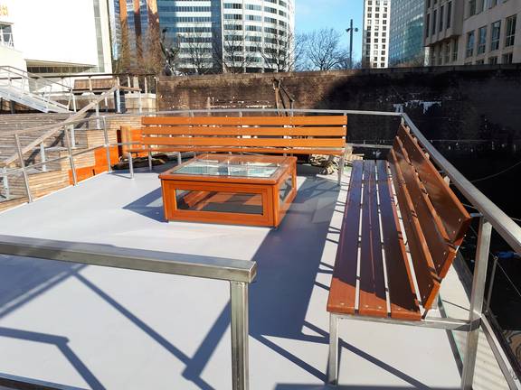 Wooden benches on the deck of the Wilhelmina moored at the quay