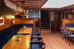 Long dining table and blue bench seating in the saloon of the Willem Barentsz