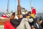 Guests sitting on the deck of the Gulden Belofte during a day trip