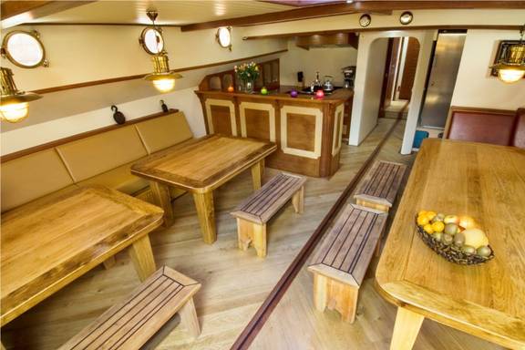Saloon of the Gulden Belofte with wooden dining tables and benches