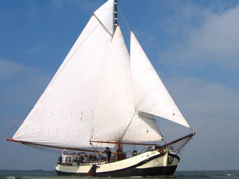 De Lis under white sails on the water