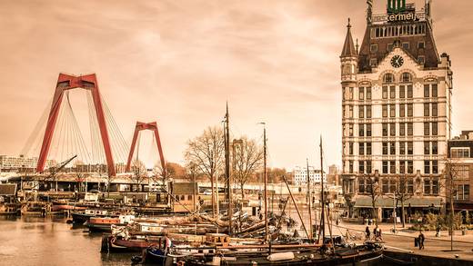Historic sailing ships moored in a city harbour in the evening light