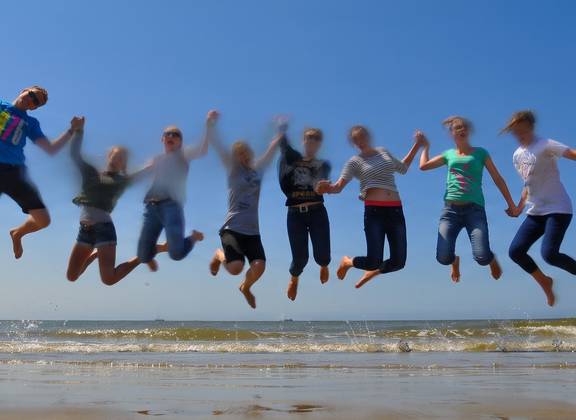 Group of school pupils jumping on the exposed tidal flats