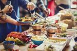 A group helping themselves to food at a buffet