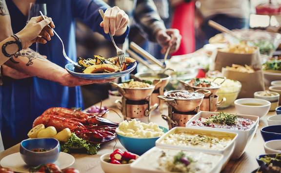 A group helping themselves to food at a buffet
