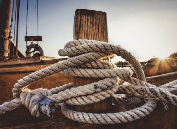 Rope around a wooden bollard on the deck of the Frisius van Adel