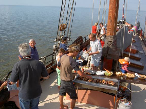 Guests having a barbecue on the deck of the Albatros while resting on the tidal flats