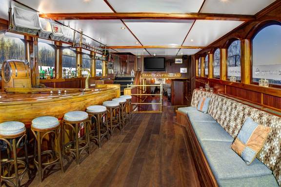 Wooden bar with bar stools and bench seating on the Mare fan Fryslân