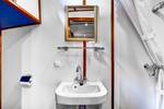 Bathroom with a shower, washbasin and mirror on the Mare fan Fryslân