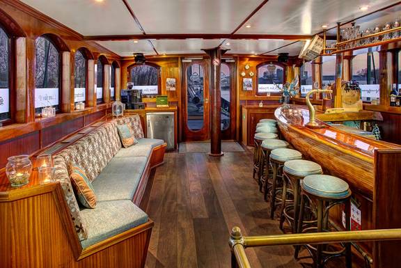 Saloon with a wooden bar and bench seating on the Mare fan Fryslân
