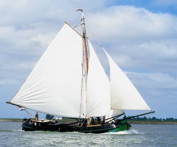 Tjalk Vrouwe Jitske under white sails on the water