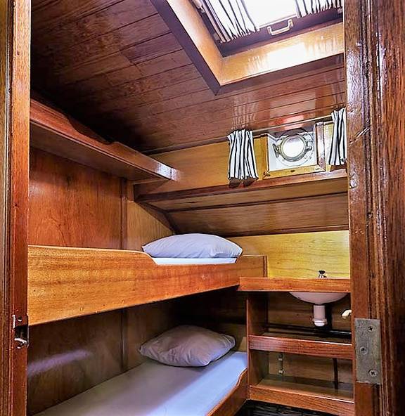 Wood-panelled cabin with bunk beds and a skylight on the Orion