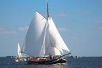 Tjalk Orion under white sails on the water