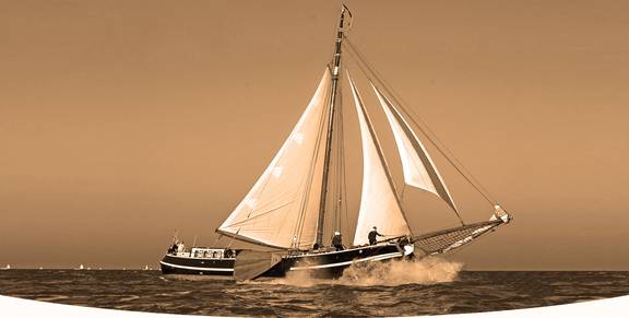 Tjalk Orion under sail in warm evening light